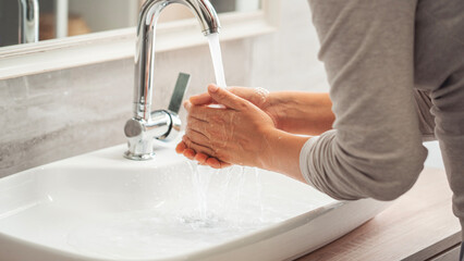 Woman washing her hands in the bathroom