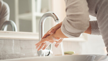 Woman washing her hands in the bathroom