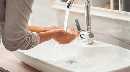 Woman washing her hands in the bathroom