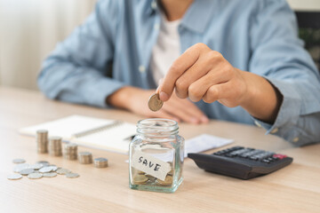 Saving money wealth concept, asian young businessman hand putting coin into jar for saving cost,...