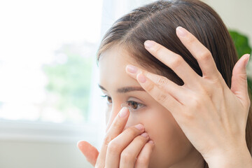 Ophthalmology care, eyesight or vision. Asian young woman, girl hand holding and putting, wearing...