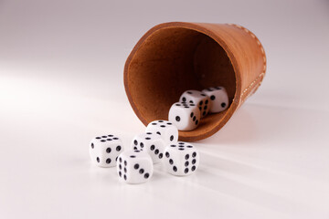 A random arrangement of dice and a puzzle cup, captured after the dice have been cast.