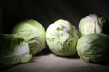 Still life with green young cabbage on dark background