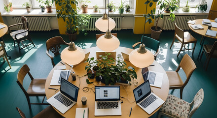 Creative Workplace With Laptops And Plants Around A Round Table