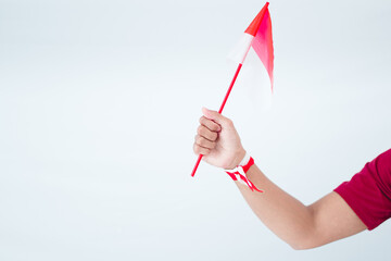 Hand Holding Indonesian Flag Against Light Gray Background
