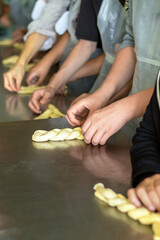 Children learn to make pastries from raw dough. Culinary master class on making buns
