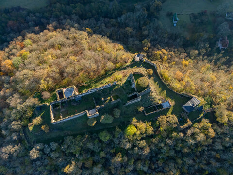 Aerial view of old castle ruins embraced by golden-leaved trees under the bright sun, its ancient stones whispering stories of forgotten times, &Auml;&OElig;abradsk&Atilde;&frac12; Vrbovok, Bansk&Atilde;&iexcl; Bystrica Region, Slovakia.
