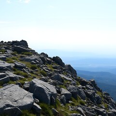 Rocky mountain slope with distant blue ocean under a clear sky