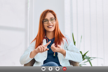 Computer screen view of smiley female doctor or GP talking to client online. Smiley woman doctor...