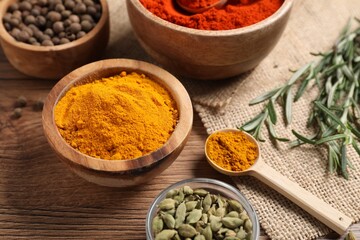 Different aromatic spices on wooden table, closeup