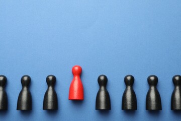 Unemployment. One red figure among black on blue background, flat lay. Space for text