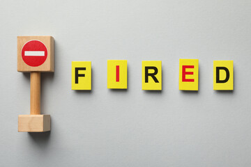 Dismissal. Word fired and stop sign on light background, top view
