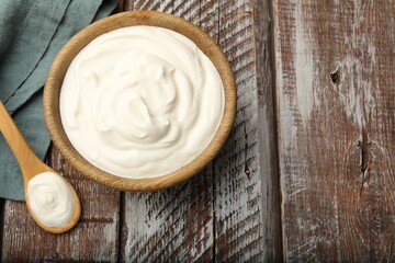 Tasty sour cream on wooden table, flat lay. Space for text