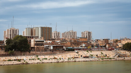 Modern buildings along the banks of the Tigris River in Baghdad, Iraq on a cloudy day