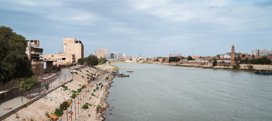 River Tigris flows through Baghdad with buildings and boats along its banks