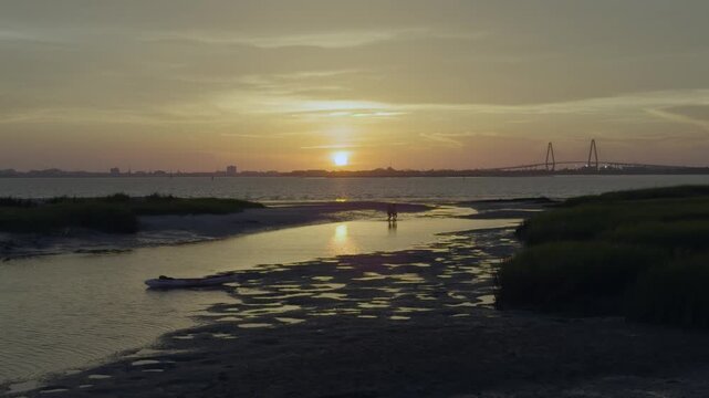 Teenage boys walking on beach during low tide during sunset in charleston South Carolina