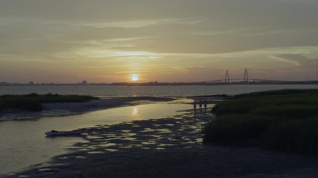 Teenage boys walking on beach during low tide during sunset in charleston South Carolina