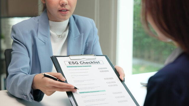Asian female audit ESG risk check list paper form net zero waste supply chain vendor eco go green carbon credit control. Asia people woman give advice report prepare work review best practice process.