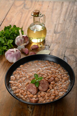  beans with sausage in a black bowl