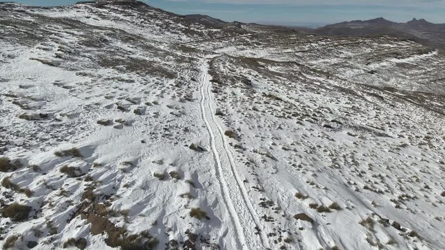 An aerial view shows deep car tracks winding through heavy snow on the Black Mountain Pass in Lesotho in July 2025. 
