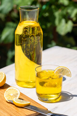Close-up of yellow-themed fresh ice-cold summer beverage with lemons