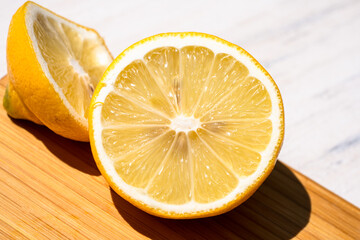 Closeup of lemon on cutting board in full sunlight with strong shadows