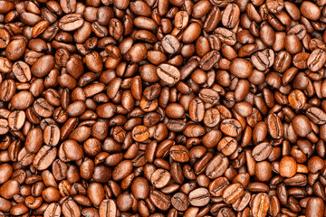 Macro top view of roasted coffee beans. Selected glossy beans fill the frame with rich brown tones and texture. Great for coffee packaging, menus, or food-related design.
