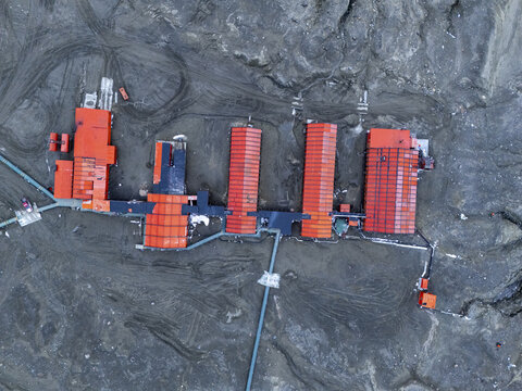 Aerial view of vibrant red buildings contrasting against the stark, grey landscape, a remote outpost in a world of ice, Seymour Island, Antarctica.