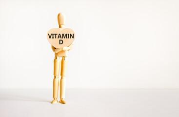 Vitamin D symbol. Concept words Vitamin D on beautiful wooden heart. Doctor's model. Beautiful white background. Copy space. Medical healthy lifestyle Vitamin D concept.