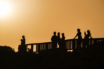 Fototapeta premium Tourists watching and photographing the sunset in the Algarve, Portugal.
