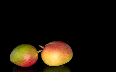 Juicy fresh mango isolated on black background, close-up.