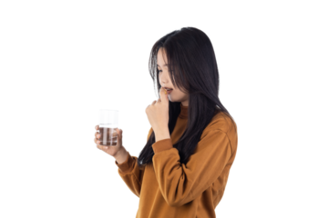 Asian woman taking a pill with a glass of water for health and wellness. Concept for medicine, treatment, vitamins, and daily supplements for self-care isolated on white background with clipping path.
