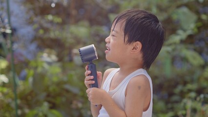 ハンディファンを使う5歳の男の子