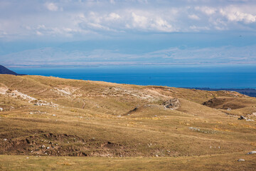 Stunning panoramic view of Lake Sevan in Armenia, showcasing rolling hills and a vast expanse of...