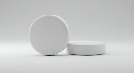 Two white cylindrical display stands on white background