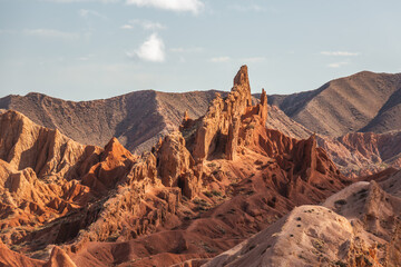 Majestic red rock formations dominate the landscape of Charyn Canyon, Kazakhstan.  A stunning natural wonder showcasing the power of erosion, creating intricate geological structures under a vast,