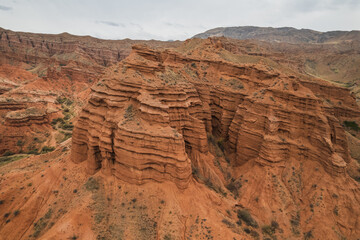 Stunning aerial view of Charyn Canyon, Kazakhstan's breathtaking red rock formations. Layers of sandstone create a dramatic landscape, showcasing nature's artistry. Explore this geological wonder!