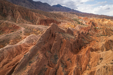 Aerial view of the stunning red rock formations in Charyn Canyon, Kazakhstan.  Rugged landscape, textured cliffs, and dramatic shadows create a breathtaking scene.