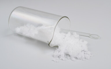 Magnesium nitrate powder on light grey background.