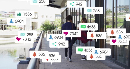 Walking along waterfront, two people with image of social media notifications
