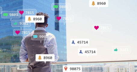 Standing on balcony, man with image of social media notifications over cityscape