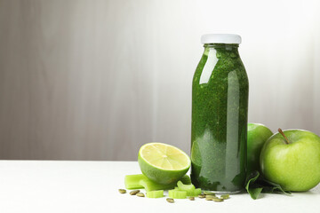 Superfood. Tasty smoothie in glass bottle and ingredients on white table, space for text