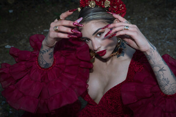 Portrait of young, beautiful, blonde woman, with red flamenco dress, flowers in her hair and gold...