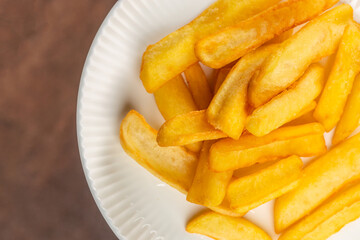Golden, crispy French fries served on a white plate, showcasing their crunchy texture and appetizing golden hue
