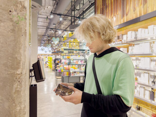 Man buying make up at cosmetics section in store. choosing cosmetics, perfumes, creams and...