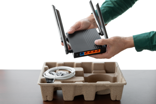 Man's hands holding new wifi router on isolated background. Unpacking new router. - Powered by Adobe