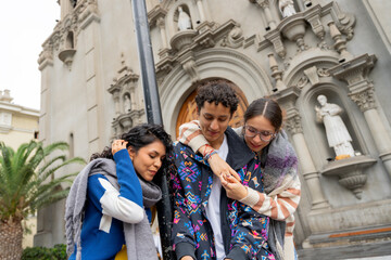 Young latin american friends enjoying a day out in the city