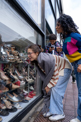 Young women window shopping for shoes with friends in city