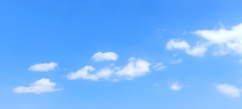 Blue sky background with white clouds in summer. Soft white clouds float in the clear blue sky. Clear blue sky, bright spring, soft sky gradient, wallpaper landscape, aerial view. - Powered by Adobe