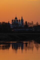 Spring landscape with an Orthodox church on the riverbank, sunset